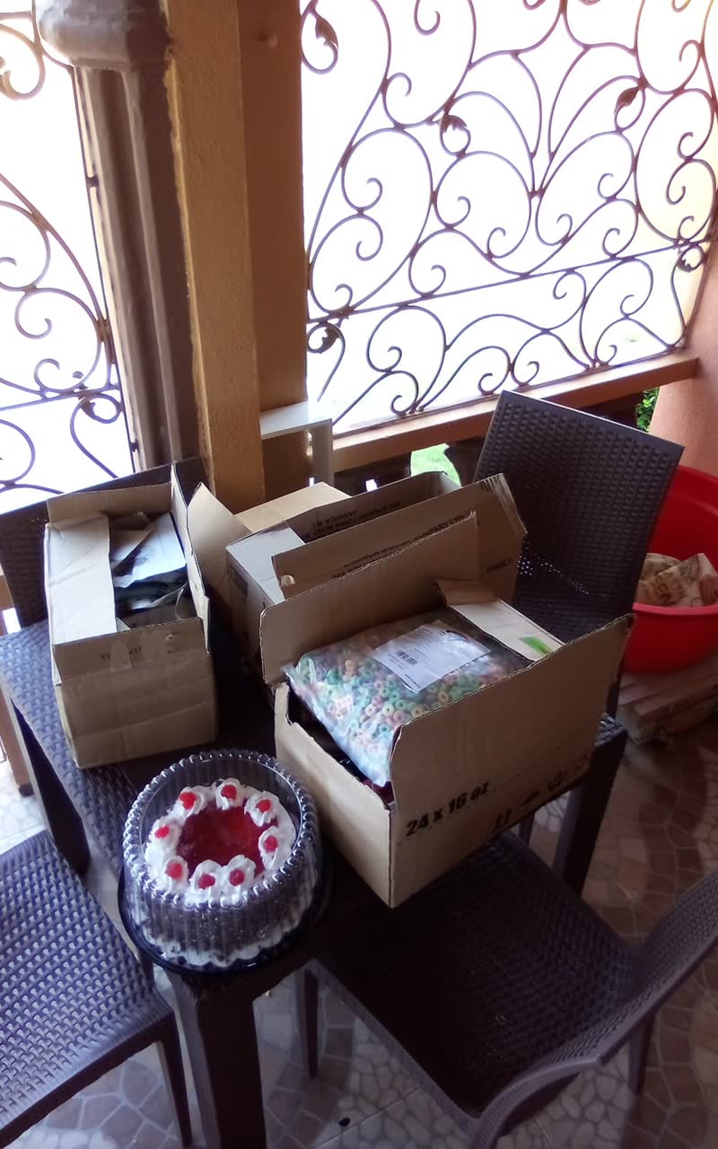 Delivered boxes of groceries, including a bag of fruit cereal, on a table next to a boxed cake